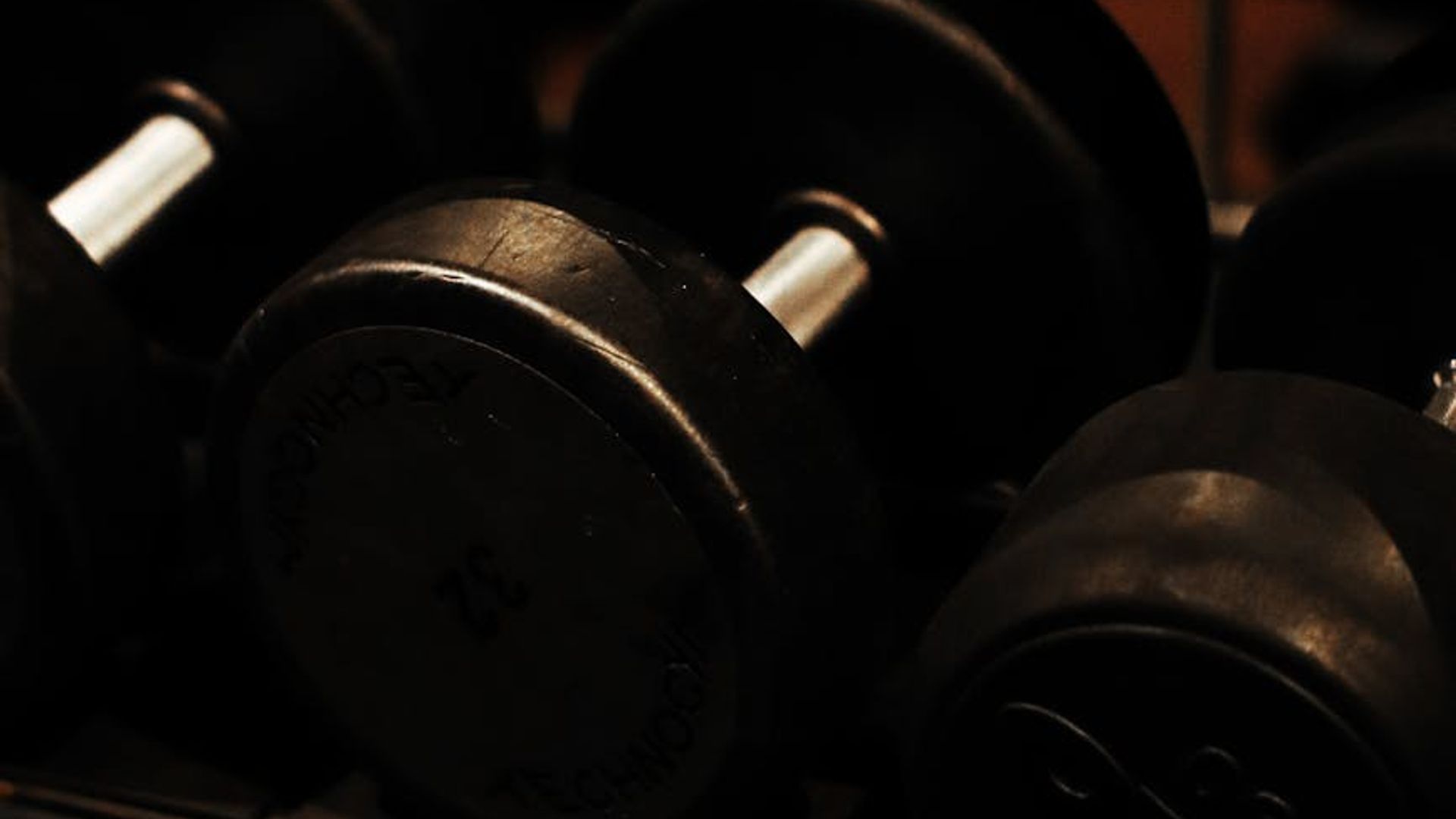 Dark atmospheric gym with professional weightlifting equipment